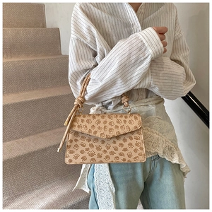 Nahaufnahme der beige quadratischen Handtasche mit Blumenmuster und Knotengriff