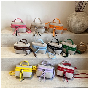 Detailed view of colorful canvas mini bags with leather tassels and dual zippers