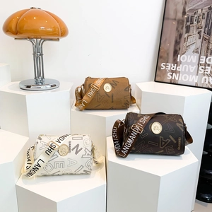 Three retro cylinder crossbody bags in beige and brown with wide branded shoulder straps
