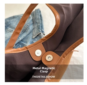 Close-up of the vintage brown tote bag featuring a secure magnetic snap button closure detail