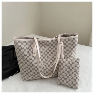 Detail view of large tote and matching clutch bag with monochrome 'M' pattern print