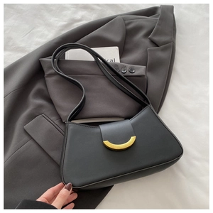 Close-up of sleek black leather shoulder bag with decorative gold crescent buckle