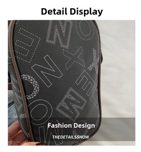 Detail of printed leather bag with white letters and brown piping on pebbled texture