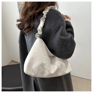 Detail of a chic marble pattern shoulder bag with a stylish ruched scrunchie strap