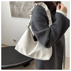 Detail der Schultertasche mit Marmormuster und gerafftem Schultergurt im Cloud-Design