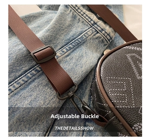 Detail of adjustable brown fabric shoulder strap with black metal hook and logo pattern bag