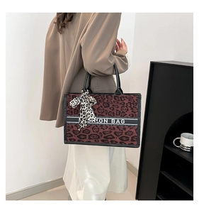 Gros plan détaillé du sac cabas léopard avec texte Fashion Bag et foulard en soie au manche