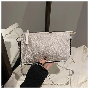 Close-up of white woven PU leather texture and silver chain strap on small square bag