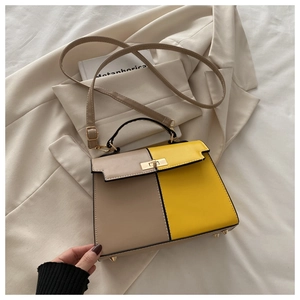 Détail du sac contrasté kaki et jaune avec fermoir rotatif en métal et poignée supérieure