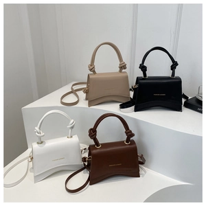 Detail view of four stylish hourglass handbags in beige, black, white, and dark brown
