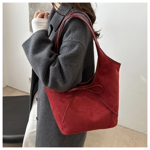 Détail du sac cabas rouge mat avec nœud décoratif et texture douce en daim synthétique