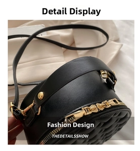 Detail of black round quilted bag featuring gold dual zippers and reinforced rivets
