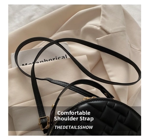 Detail of adjustable slender strap and gold hardware on black quilted handbag
