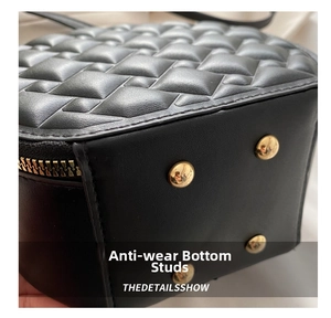 Detail view of the quilted black leather bag base with four golden protective metal feet