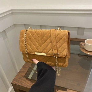 Retro caramel chain bag with V-quilted texture and gold metal bar detail in lifestyle setting