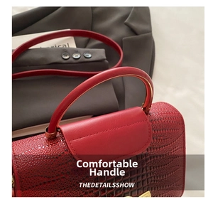 Close-up of red crocodile texture handbag featuring sturdy handle and fine embossing