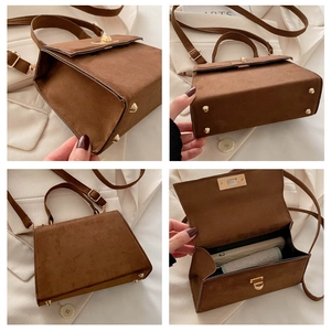 Detail view of brown matte leather handbag with gold metal lock and internal compartment