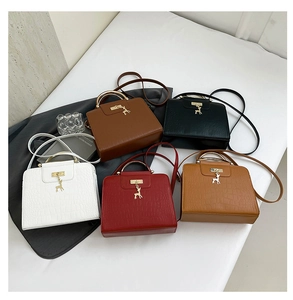 Flat lay of small crossbody bags in five colors featuring crocodile pattern and deer pendant