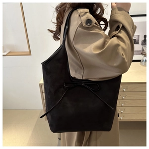 Classic black matte tote bag with bow detail styled with a khaki trench coat