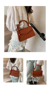 Detail view of brown faux leather crossbody bag with clover floral pattern and knotted handle