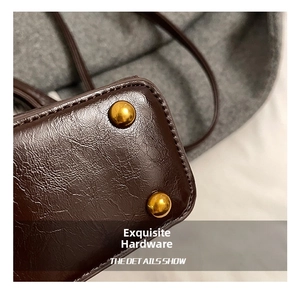 Detail of deep brown textured leather bag base with protective gold metal feet studs