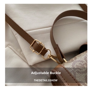 Detail of adjustable leather strap with golden metal buckle on vintage print crossbody bag