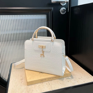 White faux crocodile skin tote bag with gold metal handle and deer charm detail