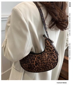 Detailed view of trendy leopard print crescent underarm bag with metal buckle adjustment