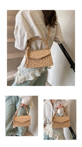 Detail view of beige crossbody bag with embossed floral patterns and knotted handle design
