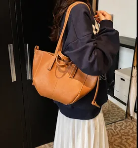 Détail du sac cabas en cuir caramel avec cordon latéral et coutures contrastées