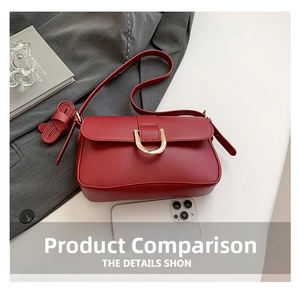 Detail view of burgundy leather bag with gold horseshoe buckle and adjustable strap