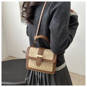 Detail view of the retro contrast crossbody bag worn by a model in a minimal setting