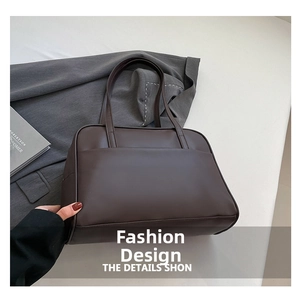 Detailed view of the dark brown leather shoulder bag with sleek front pocket design