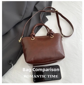 Macro detail of brown leather bucket bag with FASHION logo and size comparison to phone