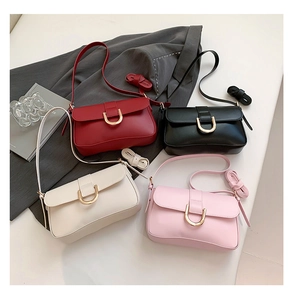 Detail view of four minimalist flap crossbody bags with golden U-shaped metal buckles