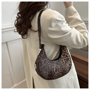 Détail du sac hobo léopard avec boucle argentée porté sur un blazer clair