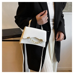 White leather handbag with gold chain detail and V-cut flap shown in a lifestyle scene