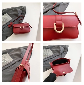 Macro view of red leather shoulder bag details including gold U-shaped buckle and strap hooks