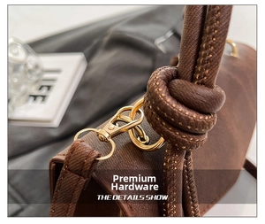 Detail of vintage brown leather bag with gold metal buckle and woven knot handle