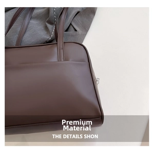 Detail of dark coffee brown tote bag featuring smooth leather and silver side zipper