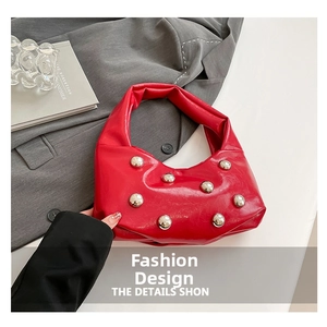 Gros plan du sac rouge en cuir verni avec des rivets sphériques argentés uniques