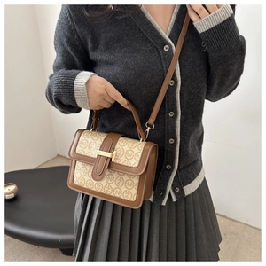 Detail of vintage beige monogram crossbody bag with brown leather trim and gold buckle