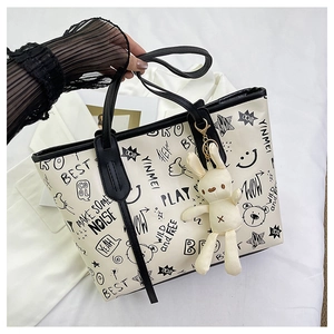 White graffiti tote bag with black street style lettering and plush bunny charm
