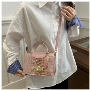 Pink crocodile-embossed handbag with elegant wave-shaped gold buckle and metal handle