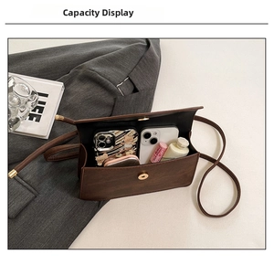 Detail view of the spacious inner compartment of this retro dark brown crossbody bag