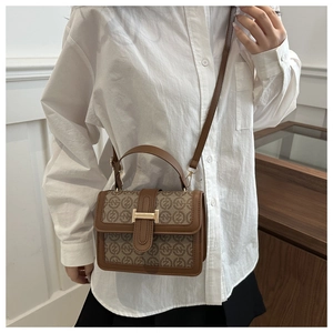 Brown retro shoulder bag with monogram print and golden H-shaped metal buckle on the flap