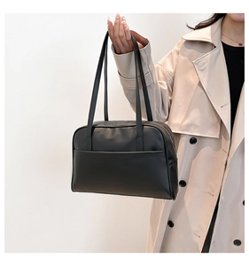Minimalist black matte leather tote bag with long handles and hidden pocket detail