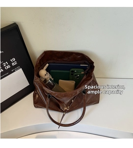 Top view of large brown tote bag showing spacious interior with tablet, phone, and umbrella