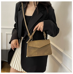 Detail of vintage brown textured handbag with knot handle and golden hardware accessories