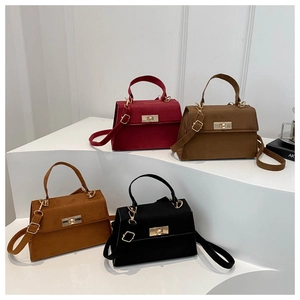 Four elegant suede handbags in red, brown, and black with golden metal twist locks